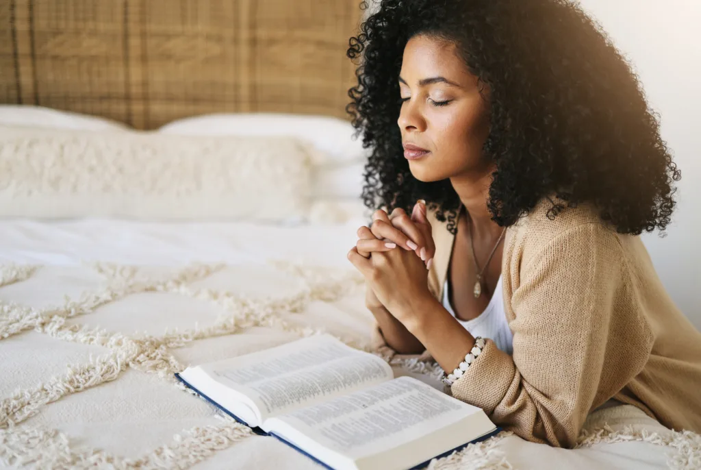 Woman in prayer with Bible open to the Psalms