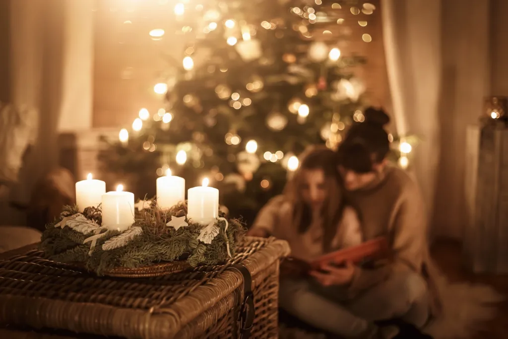How to Celebrate Advent a beautiful picture of a mom with her daughter beside a tree at Christmas