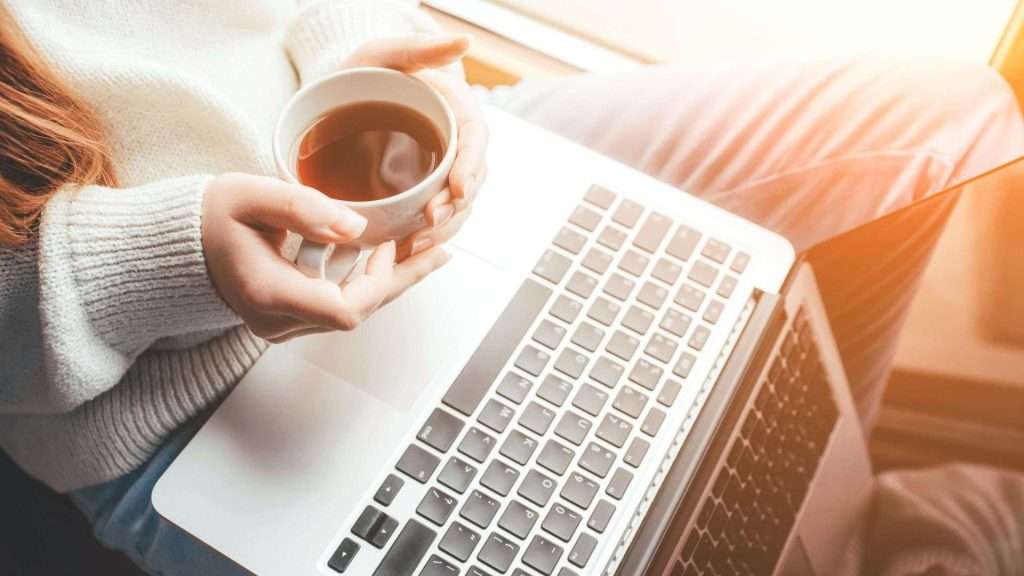 Christian woman enjoying Bible study with coffee and laptop — part of the Coffee and Bible Time online Christian community.