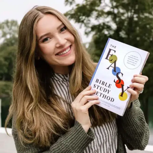 Woman holding out The Easy Method for Studying the Bible book with a gentle smile, sharing her favorite Bible study resource.