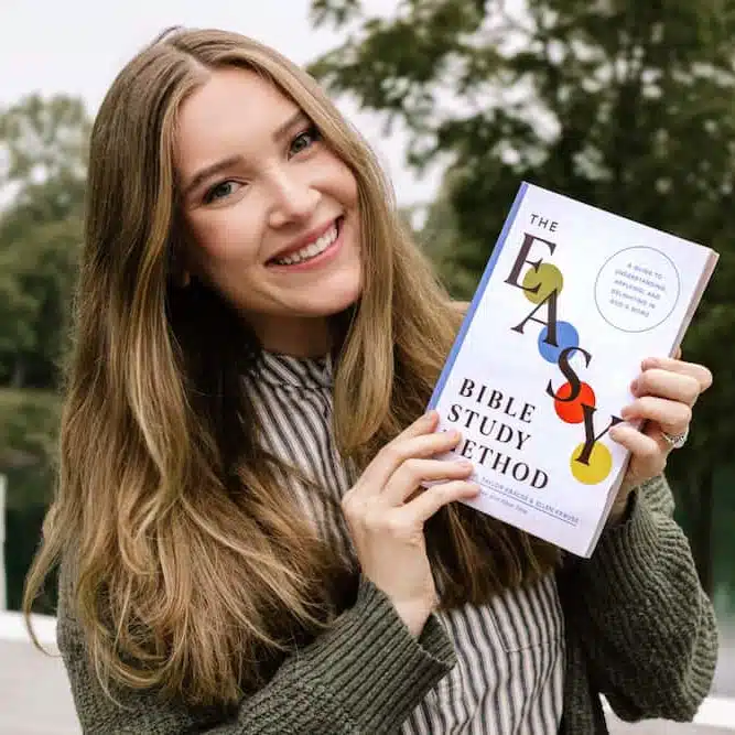 Woman holding out The Easy Method for Studying the Bible book with a gentle smile, sharing her favorite Bible study resource.