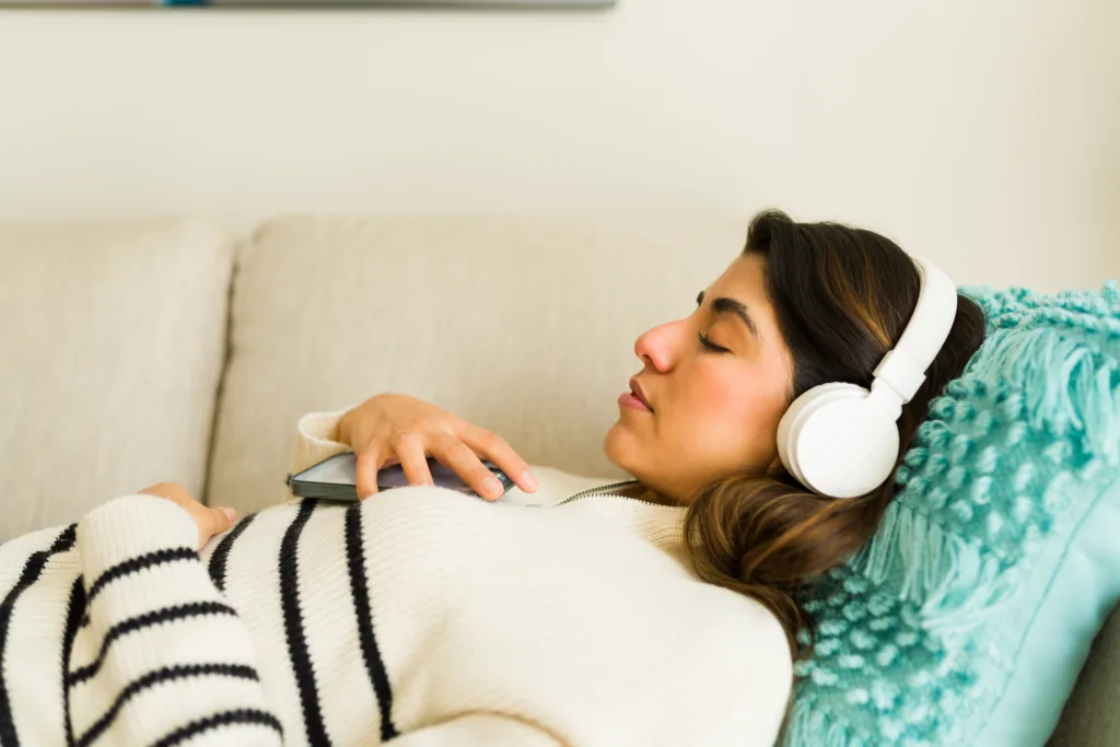 Woman lies down listening to the Bible audio