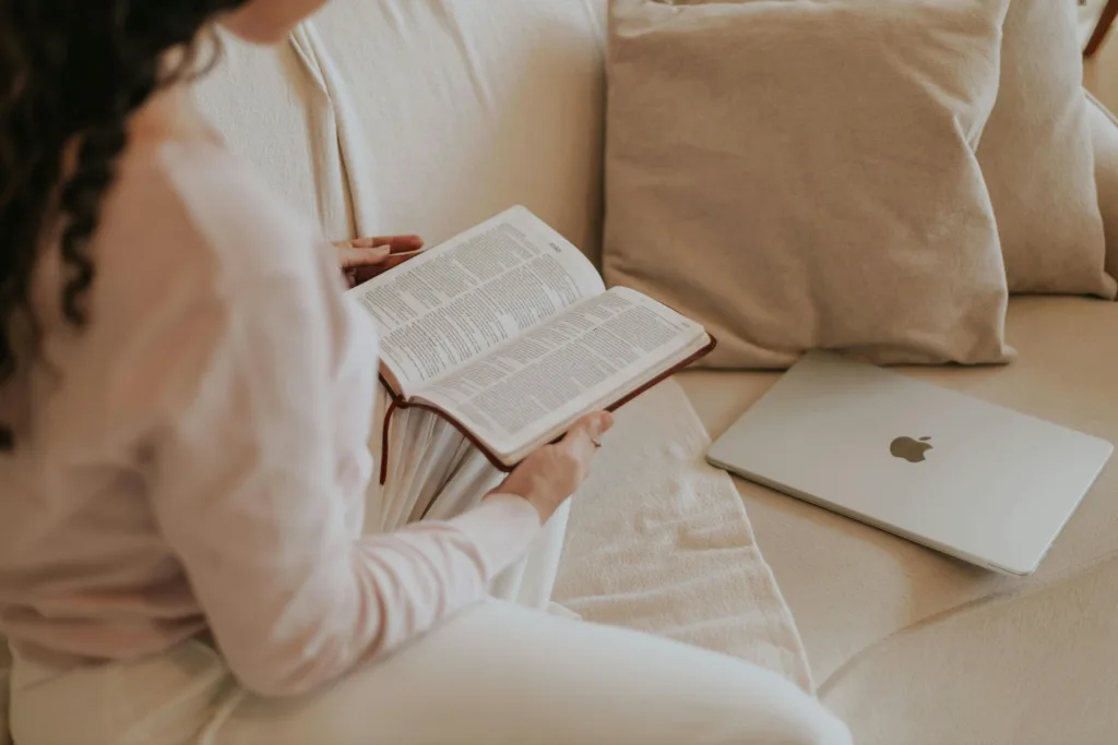 7 Day Bible Reading Plan for How to Read the Bible. Woman sitting with her Bible and a laptop on a couch. 