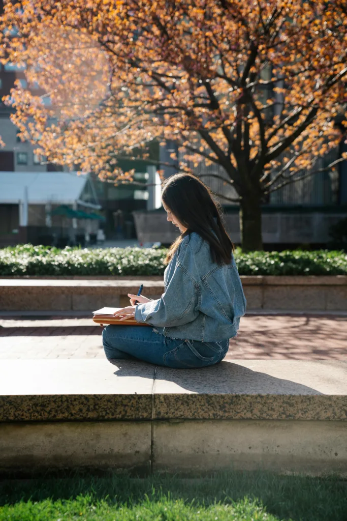 woman nurturing her relationship with God by journaling outside