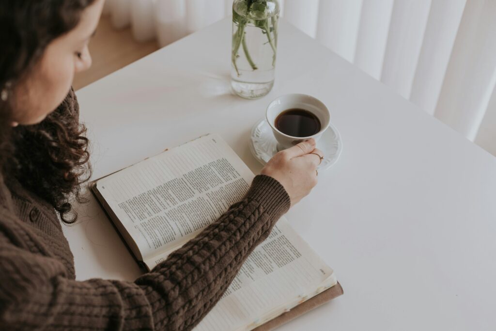 Woman drinking tea and reading her Bible, learning how to find peace in God
